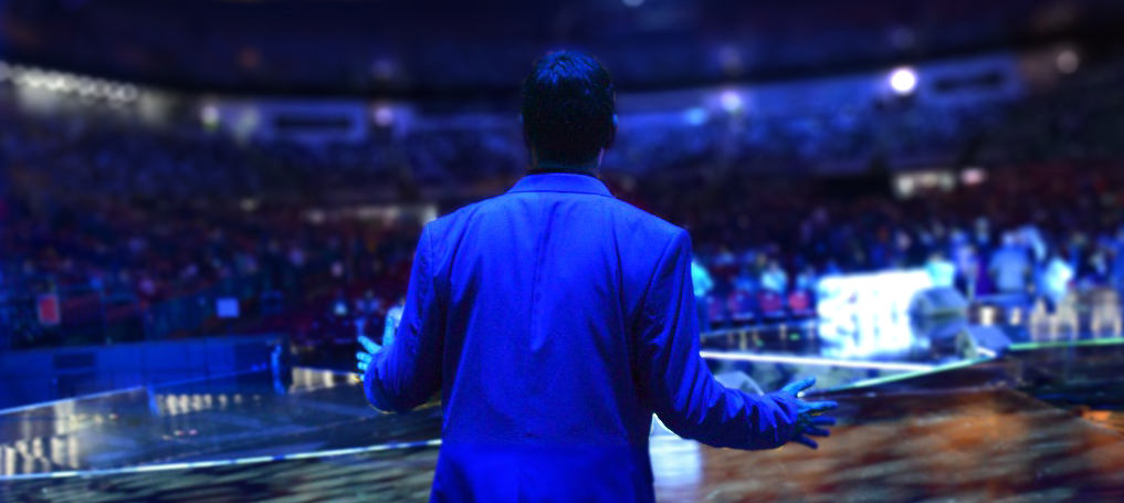 Dr. Reef Karim speaking to a full arena crowd